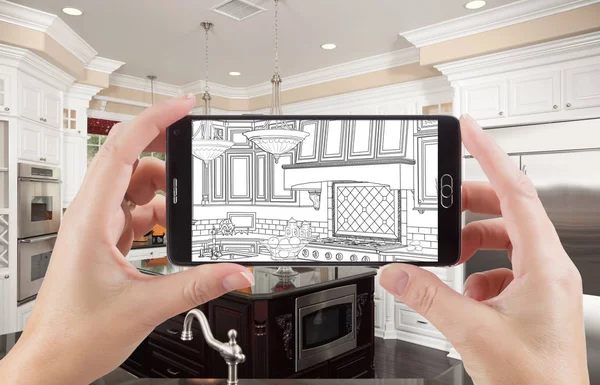 Hands Holding Smart Phone Displaying Drawing of Kitchen Photo Behind — Stock Photo, Image