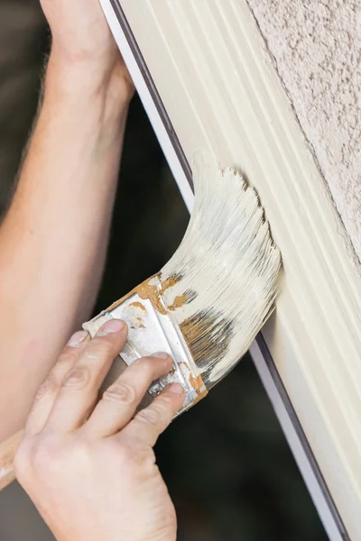 Pintor profesional que corta adentro con el cepillo para pintar el marco de la puerta de la casa — Foto de Stock