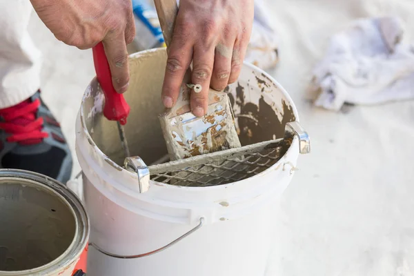 Pintor profesional que carga la pintura en el cepillo del cubo — Foto de Stock