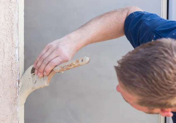 Pittore professionista che taglia dentro con la spazzola per dipingere la struttura della porta della casa — Foto Stock