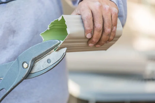 Werknemer snijden aluminium regengoot met een zware schaar — Stockfoto