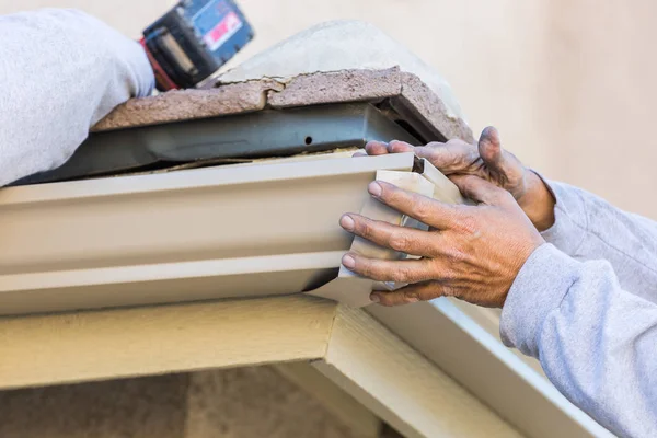 Arbetare Fäst aluminium regnränna till fascian av huset. — Stockfoto