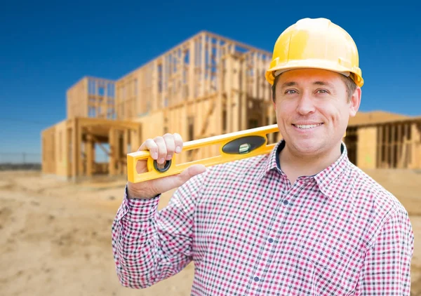 Glimlachend mannelijke aannemer in veiligheidshelm Holding blauwdrukken en niveau — Stockfoto