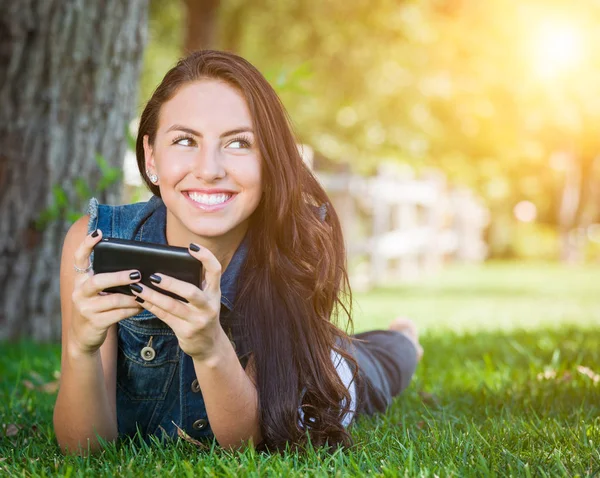 Mischlingshündin textet auf Handy draußen im Gras — Stockfoto