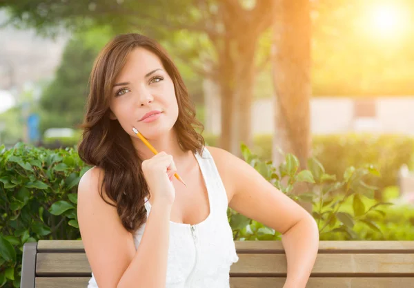 Young Adult Female Student with Pencil on Bench Outdoors — Stock Photo, Image