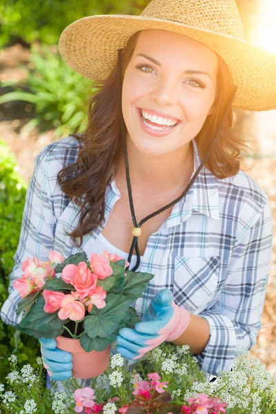 Açık havada bahçe eldiven ve şapka giyen genç yetişkin kadın — Stok fotoğraf