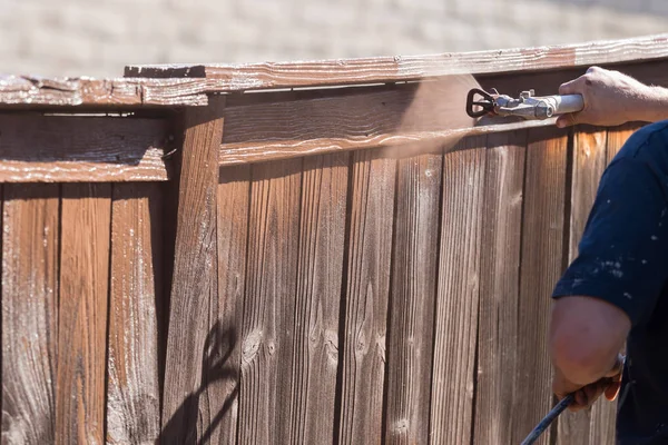 Professionella målare sprutning gården staket med fläck — Stockfoto