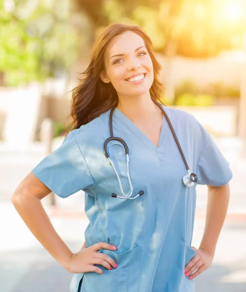 Mujer joven adulta Doctor o enfermera sosteniendo la almohadilla táctil afuera . — Foto de Stock