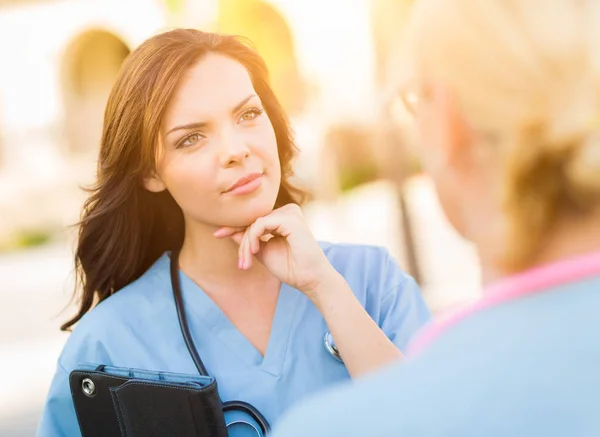 Mujer joven adulta Doctor o enfermera sosteniendo la almohadilla táctil afuera . — Foto de Stock