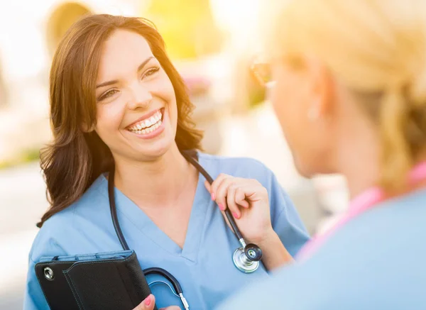 Zwei junge professionelle Ärztinnen oder Krankenschwestern sprechen draußen — Stockfoto