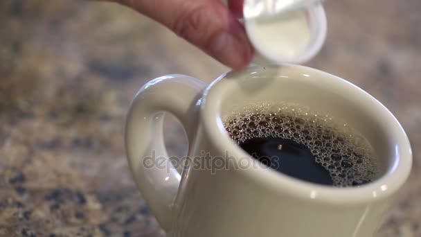 Verser et remuer la crème dans une tasse à café 