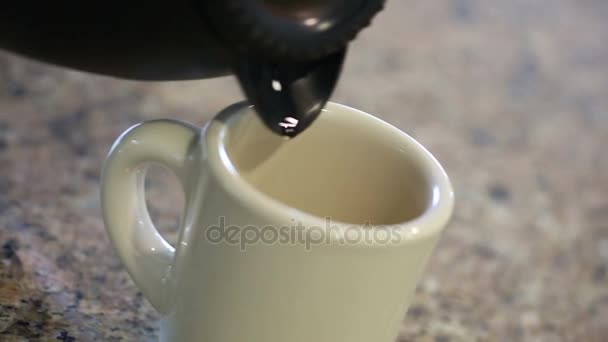 Casserole versant du café et remuant crème dans la tasse 