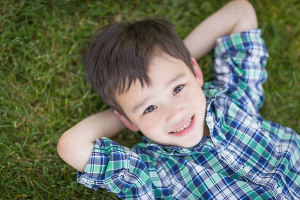 Mixed Race Chinese and Caucasian Young Boy Relaxing On His Back — Stock Photo, Image