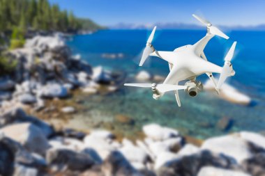 İnsansız uçak sistemi (İHA) Quadcopter dron Lake Tahoe üzerinde havada.