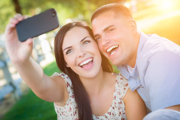 Casal de raça mista feliz tomando auto retrato com um telefone inteligente — Fotografia de Stock