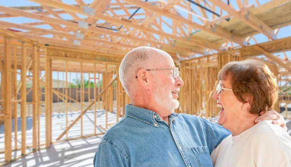 Pareja mayor en el sitio dentro de su nuevo marco de construcción de casas — Foto de Stock