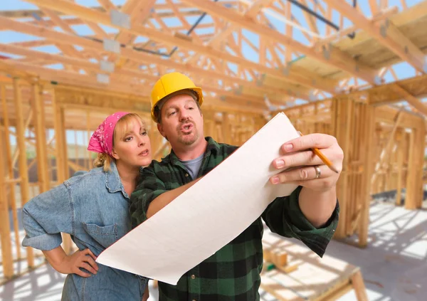 Entrepreneur montrant des plans à la femme sur place à l'intérieur de la construction d'une nouvelle maison Cadrage . — Photo