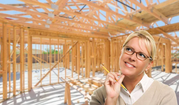 Zamyšlená žena s tužkou na místě uvnitř nová výstavba domů rámování. — Stock fotografie