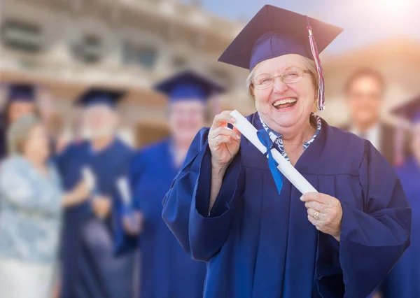 Glückliche erwachsene Seniorin in Mütze und Kleid bei Outdoor-Abschlussfeier — Stockfoto