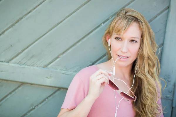 Utomhus porträtt av unga vuxna Brown Eyed kvinna med solglasögon och lyssnar på musik med hennes hörlurar. — Stockfoto