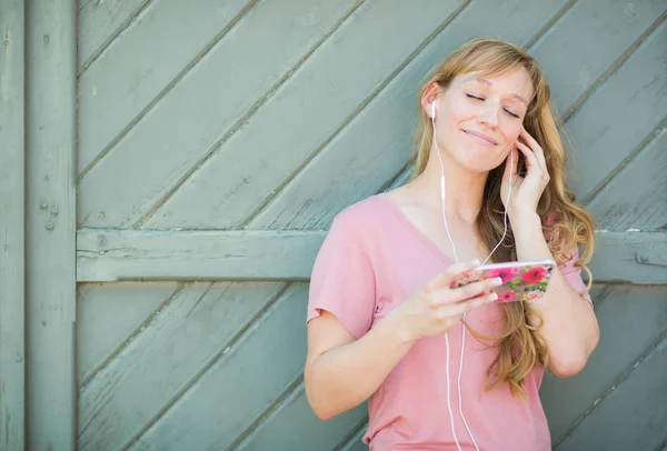 Outdoor Portrait of Young Adult Brown Eyed Woman Listening To Music with Earphones on Her Smart Phone. — Stock Photo, Image