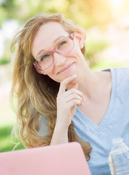 야외에서 그녀의 노트북을 사용 하 여 안경을 착용 하는 젊은 성인 여자. — 스톡 사진