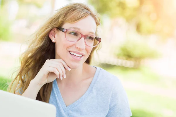 Νεαρή ενήλικη γυναίκα που φοράει γυαλιά σε εξωτερικούς χώρους χρησιμοποιώντας το Laptop της. — Φωτογραφία Αρχείου