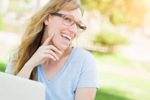Молодая женщина носит очки на открытом воздухе с помощью ноутбука . — стоковое фото