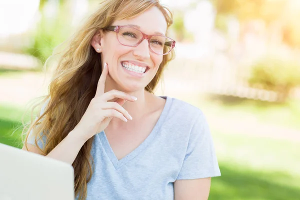 Молода жінка носить окуляри на відкритому повітрі за допомогою ноутбука . — стокове фото