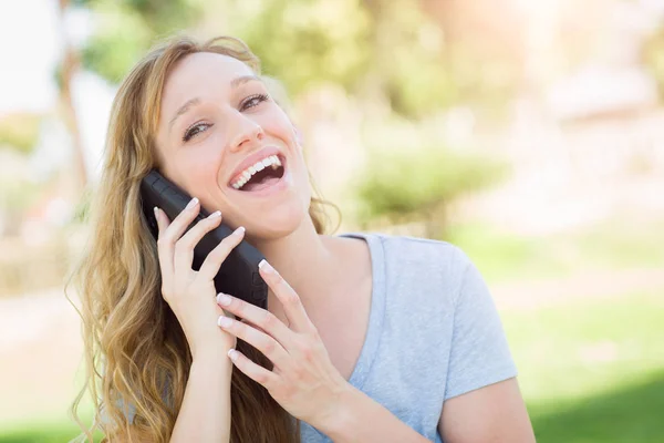 Junge erwachsene Frau spricht im Freien mit ihrem Smartphone. — Stockfoto