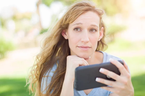 Обеспокоенная молодая женщина на улице, глядя на ее смартфон . — стоковое фото