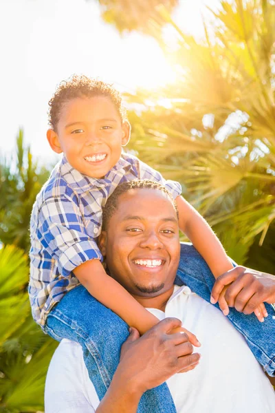 Mixed Race Son and African American Father Playing Piggyback Outdoors Together. — Stock Photo, Image