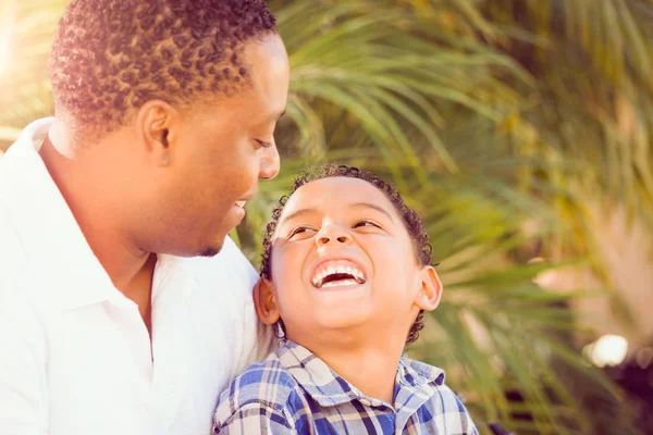Hijo de raza mixta y padre afroamericano jugando al aire libre juntos . — Foto de Stock