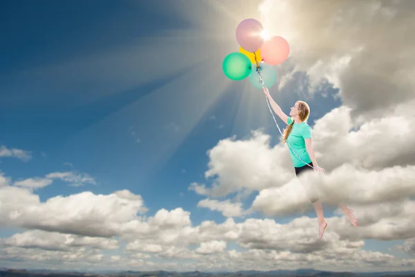 彼女が保持している風船で雲に入ると先を行われている若い大人の女性. — ストック写真