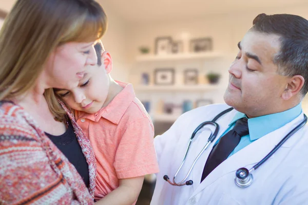 Jonge zieke jongen en moeder bezoeken met Hispanic Doctor in Office. — Stockfoto
