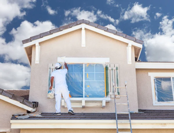 Pintor de casa profissional pintando a guarnição e as persianas de uma casa . — Fotografia de Stock