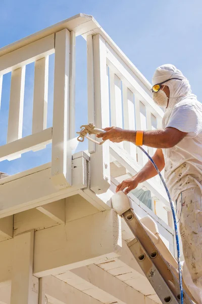 Professionele huisschilder dragen gezichts bescherming Spray schilderij dek van een huis. — Stockfoto