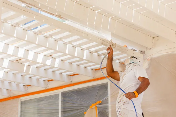 Pintor profesional de la casa que usa la cubierta de pintura del aerosol de la protección facial de un hogar . — Foto de Stock