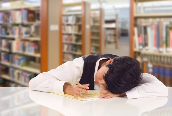 Jovem estudante de raça mista feminina estressada e frustrada na biblioteca com almofada de papel em branco . — Fotografia de Stock