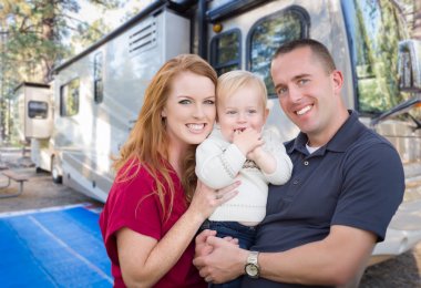 Happy Young Military Family In Front of Their Beautiful RV At The Campground. clipart
