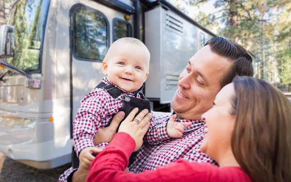 Gelukkige jonge Kaukasische familie voor hun mooie camper op de camping. — Stockfoto