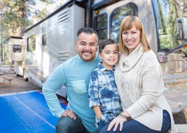 Feliz joven mixta raza familia en frente de su hermosa casa rodante en el camping . — Foto de Stock