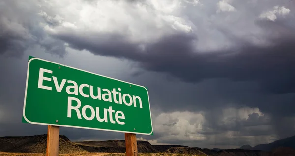 Evacuatie Route groen verkeersbord en stormachtige wolken — Stockfoto