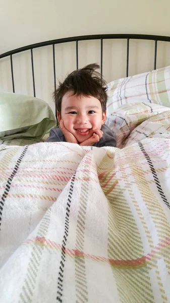 Cute Young Chinese and Caucasian Boy Waking Up on Bed — Stock Photo, Image