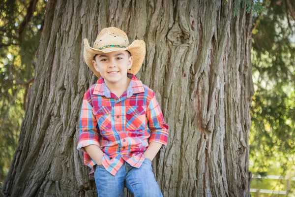 Mixte Race jeune garçon portant Cowboy chapeau debout à l'extérieur . — Photo