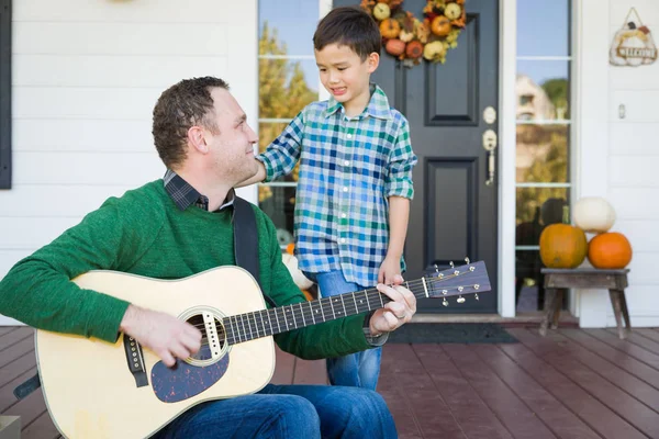 Jeune métis chinois et caucasien fils chanter des chansons et jouer de la guitare avec père — Photo