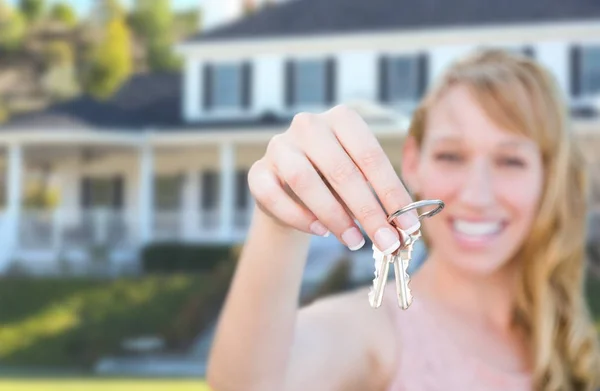 Aufgeregtes Weibchen hält Hausschlüssel vor hübschem neuen Zuhause. — Stockfoto