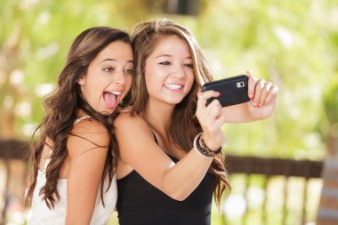 Selfie açık havada için akıllı cep telefonlarını kullanarak iki çekici karışık yarış kız arkadaşım