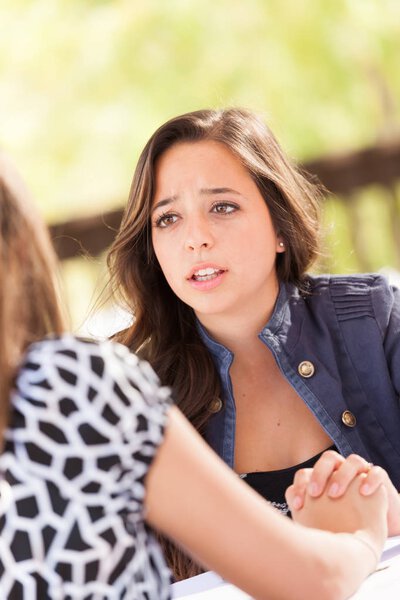 Обеспокоенная молодая взрослая женщина разговаривает со своим другом
