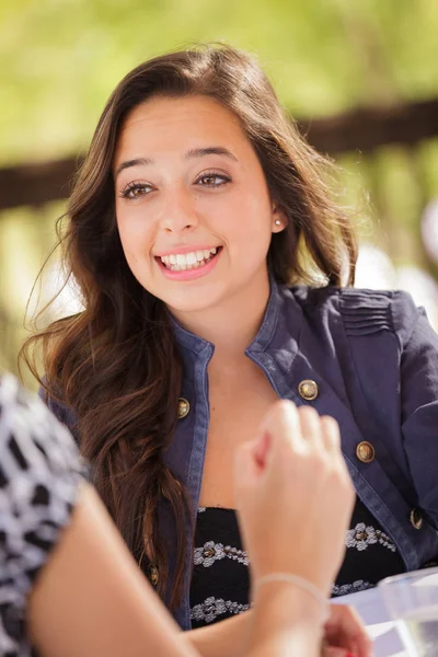 Expressieve jonge volwassen vrouw met drinken en praten met haar vriend buitenshuis — Stockfoto